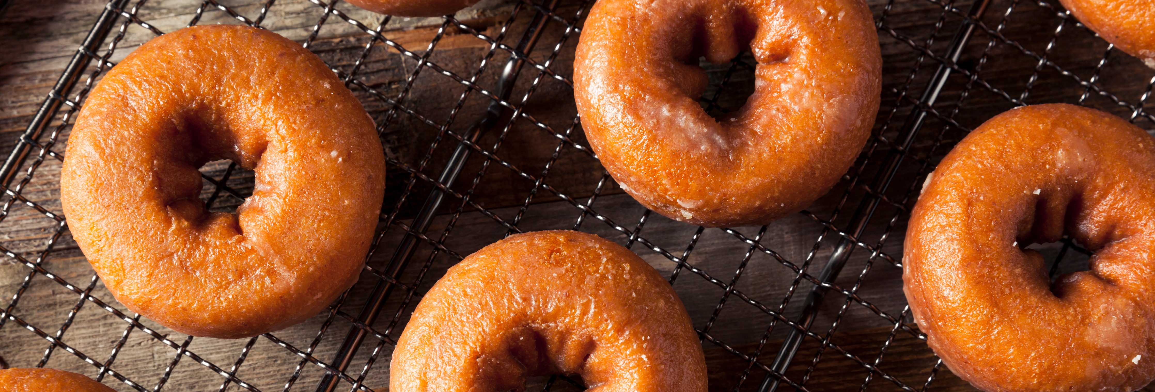 Overhead view of healthy pumpkin protein donuts showcasing golden brown ring shapes on a wire cooling rack