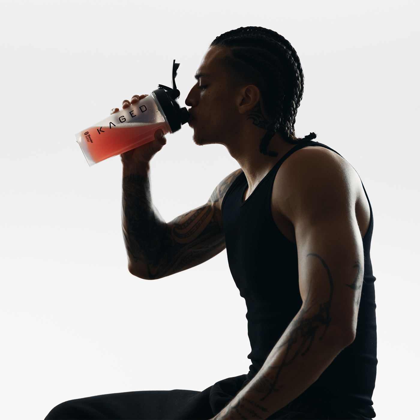 Person drinking from clear 28 oz Blender Bottle with KAGED logo against a white background